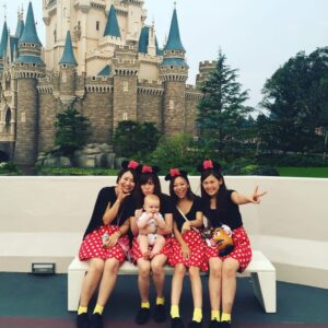 Baby at Tokyo Disneyland surrounded by girls wearing Minnie outfits